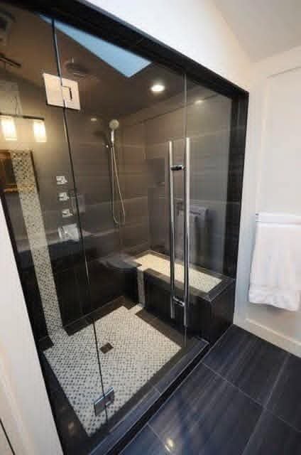 Bathroom walk-in shower with black tile and frameless glass