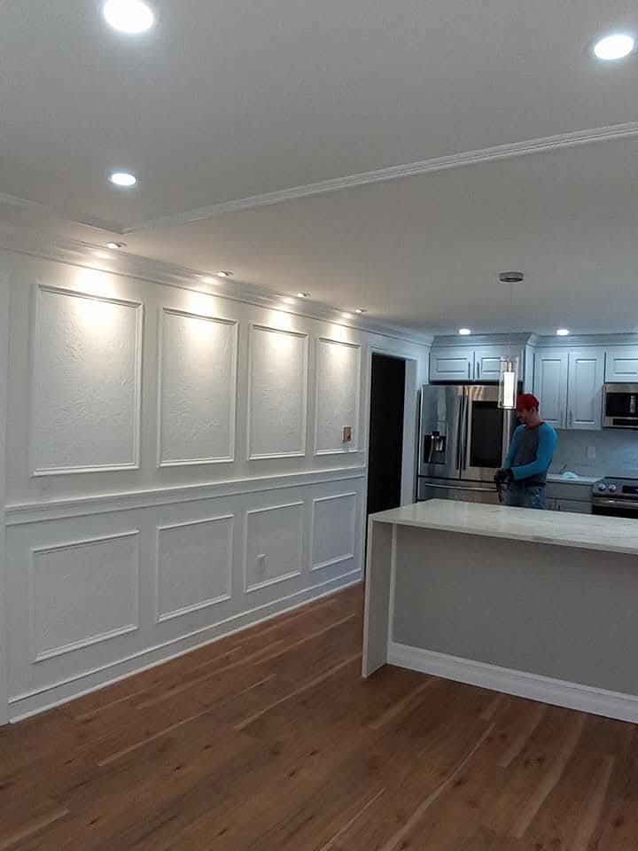 Kitchen island with paneled walls and recessed lighting