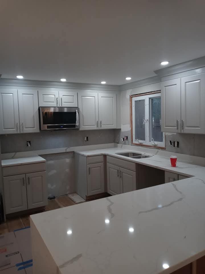 Kitchen with white cabinets, stainless appliances and quartz counters