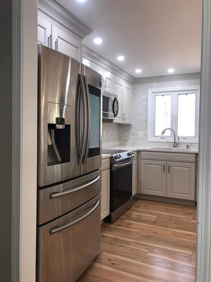 Kitchen with stainless steel refrigerator and range